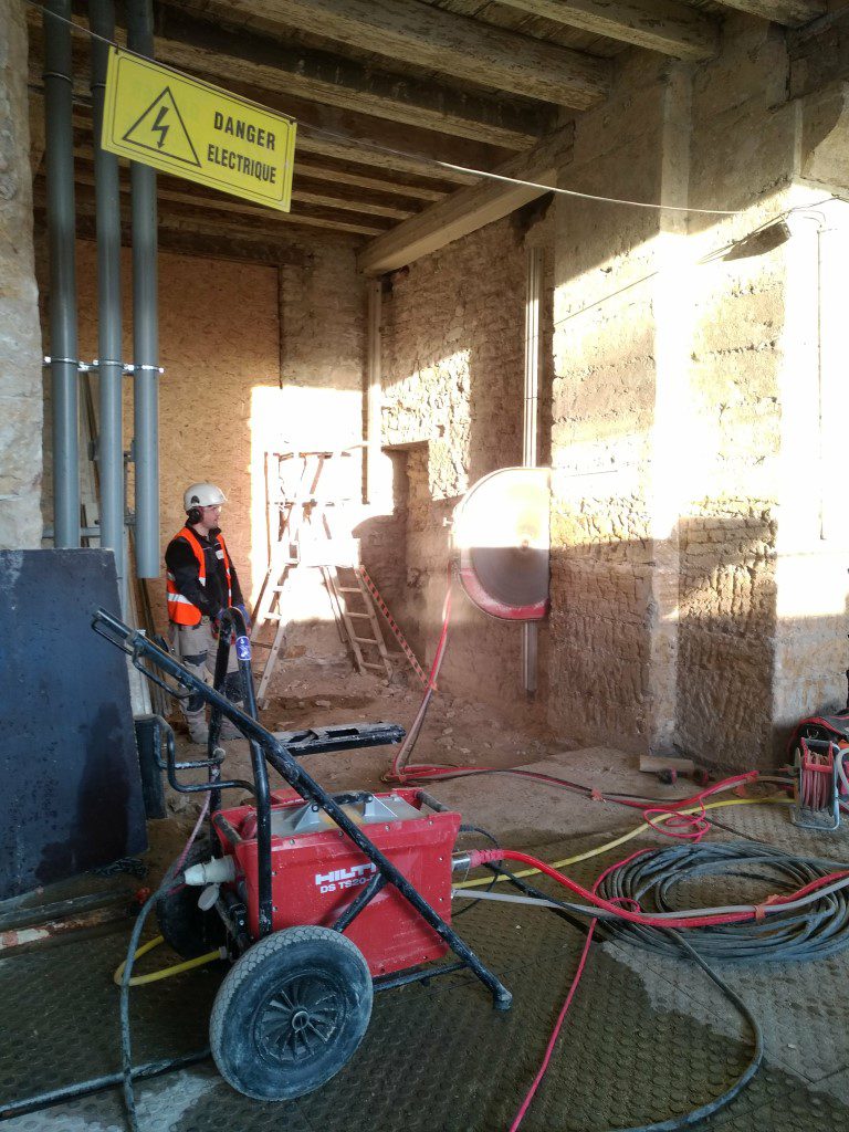 Un scieur est en train de scier un mur en pierre